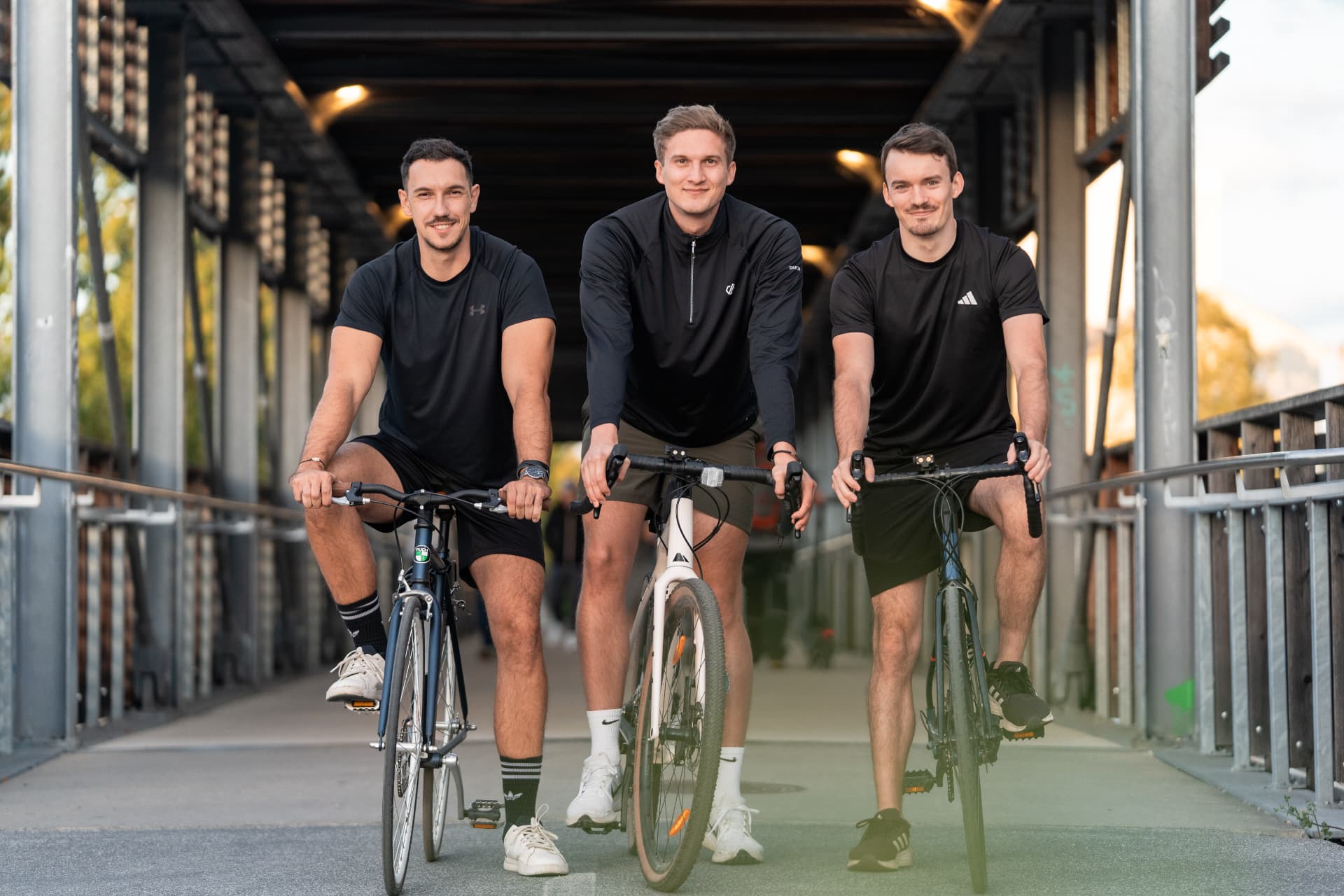 Drei Radfahrer:innen mit Gravelbikes auf einer Brücke